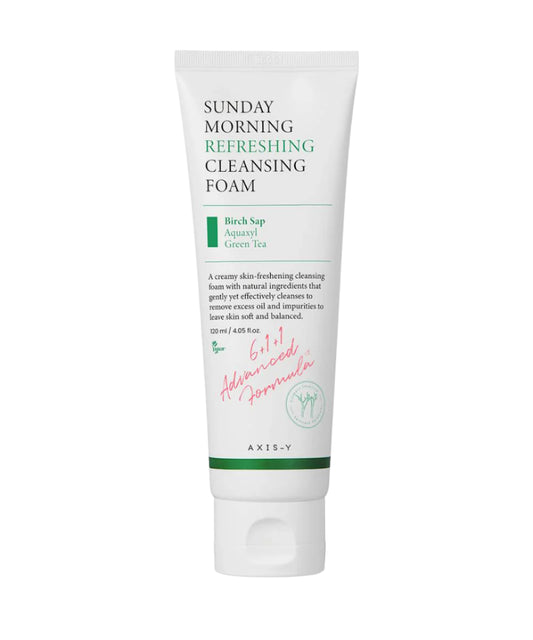 The Axis-Y Sunday Morning Refreshing Cleansing Foam 120ml by AXIS-Y, in a white tube, contains birch sap, aquaxyl, and green tea for sensitive skin. The pink signature reads Advanced Formula with Aquaxyl care technology and holds 120 ml or 4.05 fl oz.
