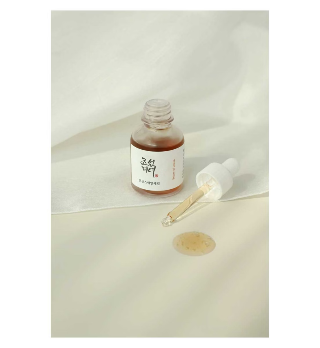 Skincare serum bottle with dropper on a light background