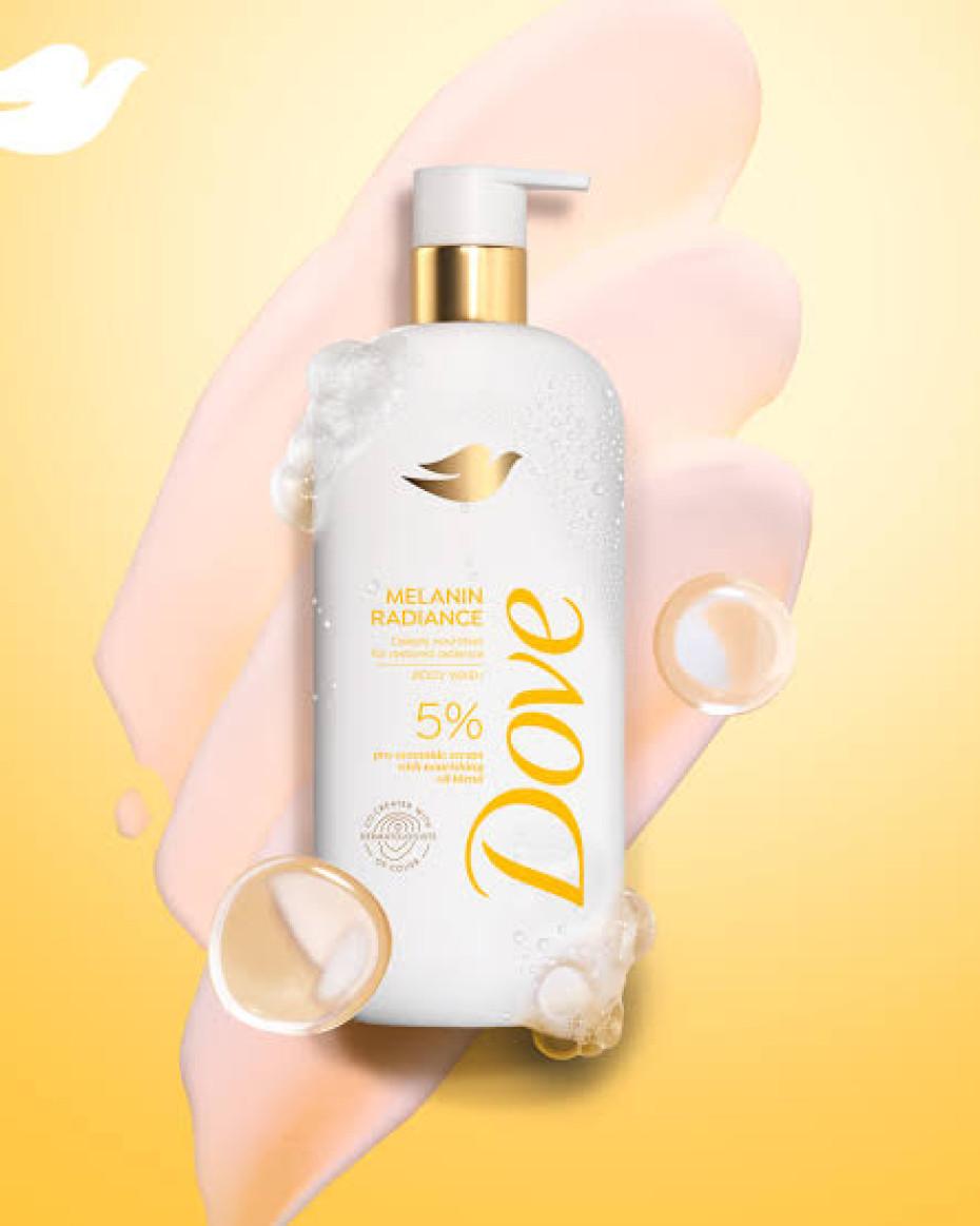 A Dove Melanin Radiance Body Wash 5% Pro-Ceramide Serum bottle, featuring a peach and beige background with swirling bubbles. Designed for melanin-rich skin, this moisturizing formula in a pump dispenser prominently showcases the Dove logo.