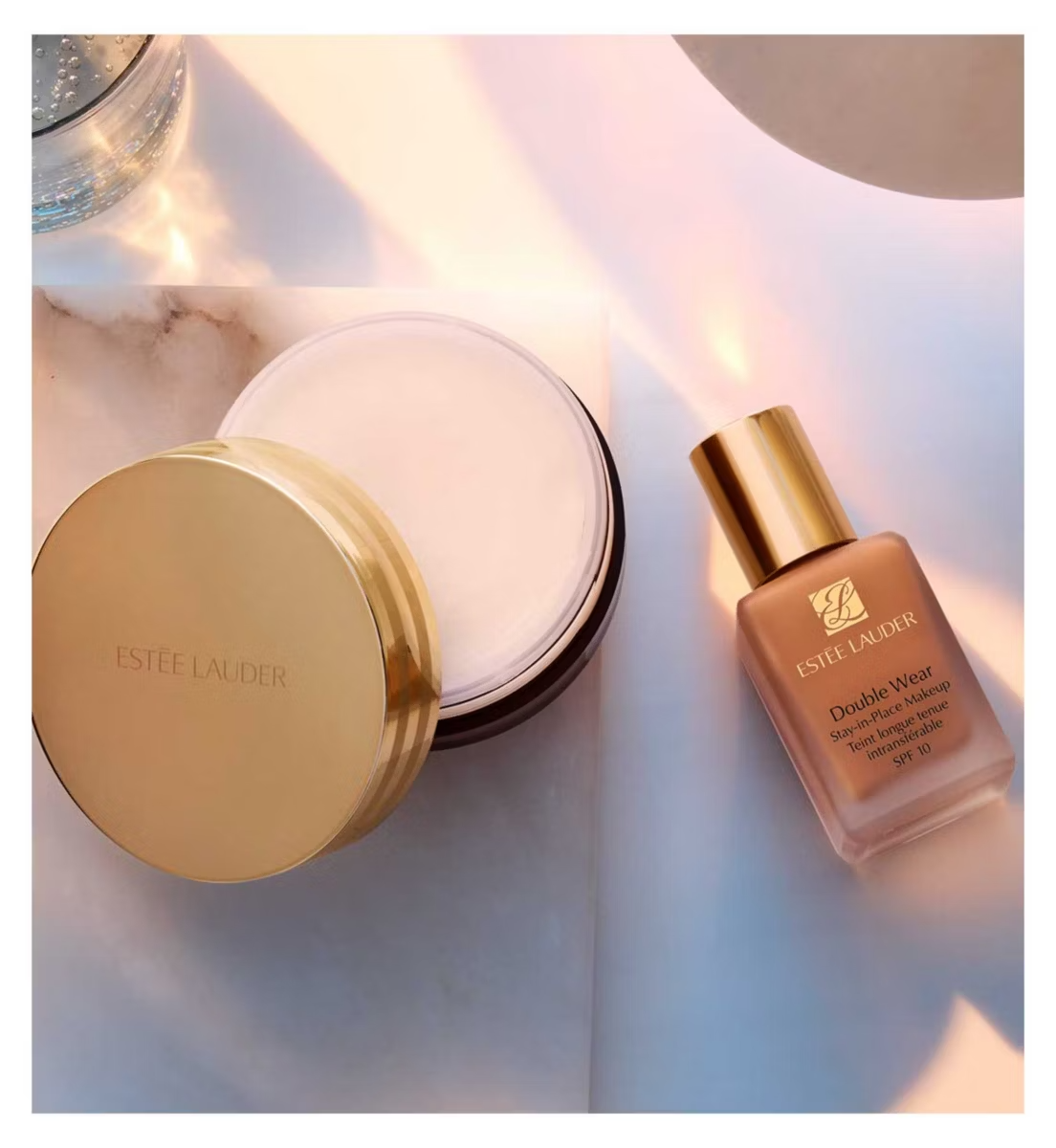 Estée Lauder makeup products on a marble surface