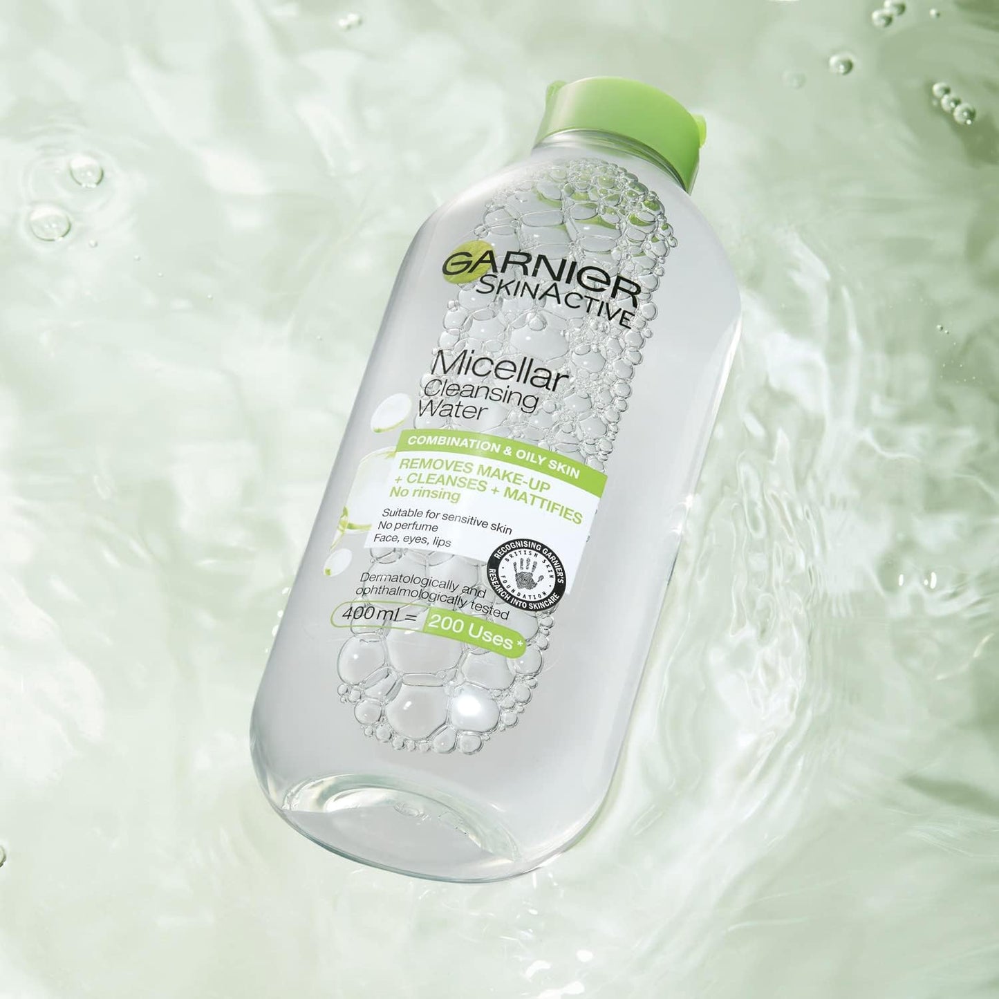 A bottle of Garnier Micellar Cleansing Water, a premier makeup remover for combination and oily skin, floats on rippled light green water. The transparent bottle with a green cap highlights its no-rinse formula.