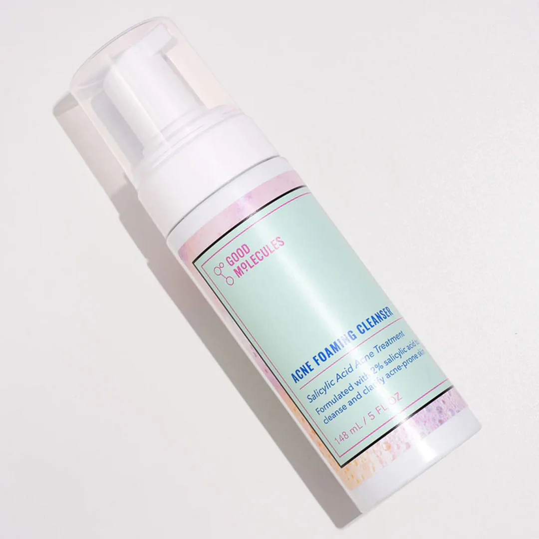 A bottle of Good Molecules Acne Foaming Cleanser with Salicylic Acid BHA is set against a light background. The mint green label, accented with vibrant colors, highlights salicylic acid as a key ingredient in this 148ml acne-fighting exfoliating face wash, featuring a convenient pump top.