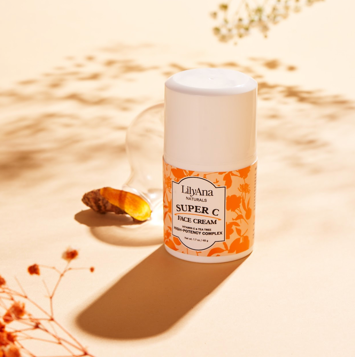 LilyAna Super C face cream jar on a beige background with dried flowers.