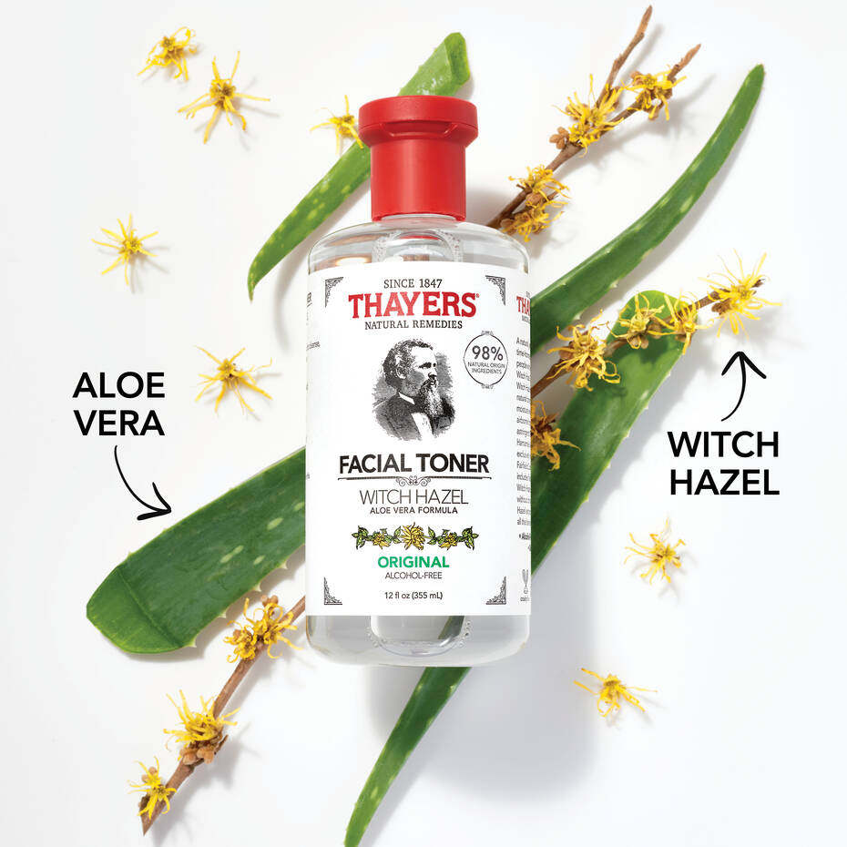 The THAYERS Facial Toner - Witch Hazel Aloe Vera Formula - Original is set against aloe vera leaves and witch hazel flowers, highlighting its natural ingredients. Arrows point to Aloe Vera and Witch Hazel. The alcohol-free toner comes in clear packaging, showcasing its purity.