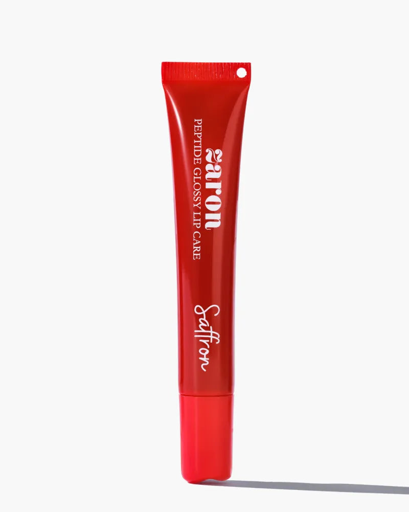 A red squeeze tube of Zaron Saffron Peptide Glossy Lip Care standing upright on a light gray background with a soft shadow.