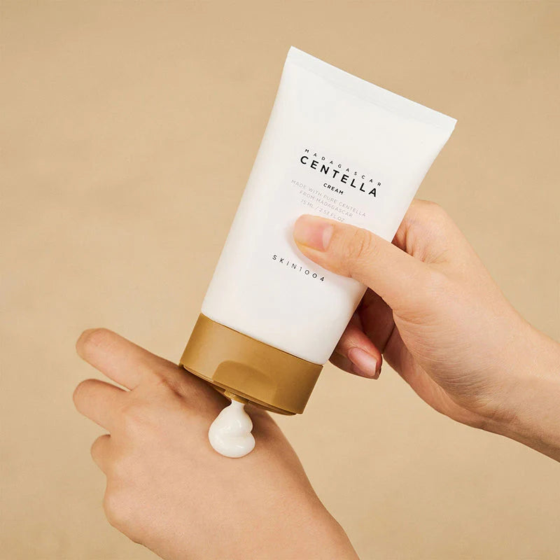 SKIN1004 Madagascar Centella Cream being dispensed onto a hand, showcasing its rich, hydrating texture for soothing sensitive and dry skin.