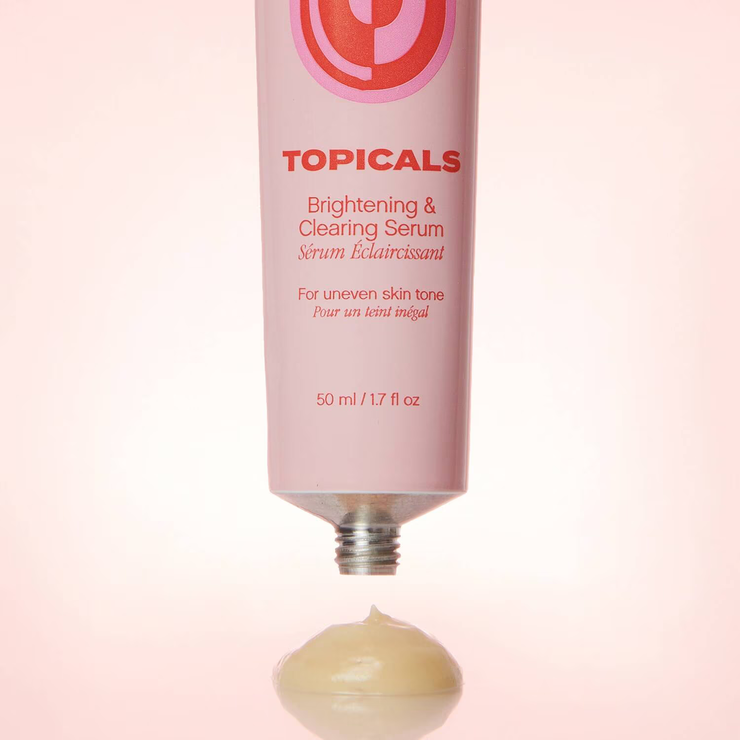 A pink tube of Topicals Faded Brightening and Clearing Serum 50ml, with red text, ideal for sensitive skin and targeting dark spots. A small amount of the light-colored cream is dispensed, all set against a soft pink background.