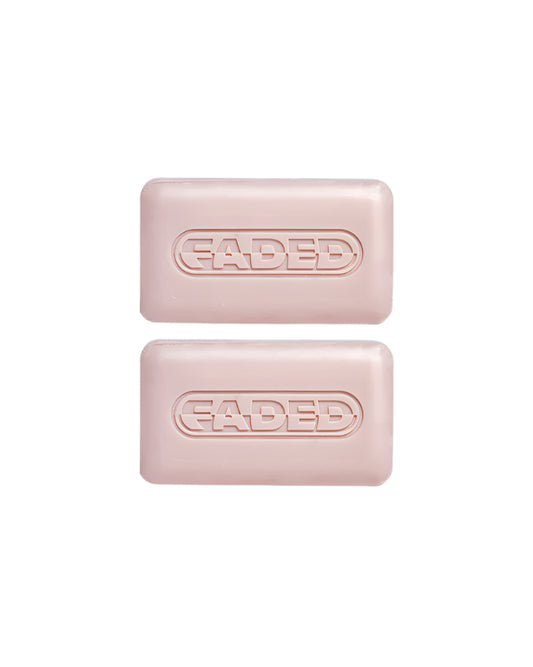 Two rectangular pink bars of Topicals Faded Cleansing Bar, embossed with the word 'FADED' in bold capital letters, displayed against a light background.