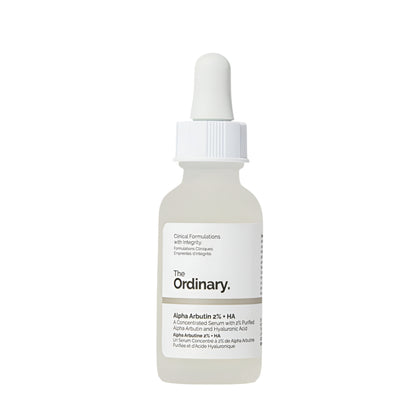 A white dropper bottle of The Ordinary Alpha Arbutin 2% + HA Serum 30ml targets hyperpigmentation, featuring the brand name and product details on the label. The cap includes a dropper for application against a plain white background.
