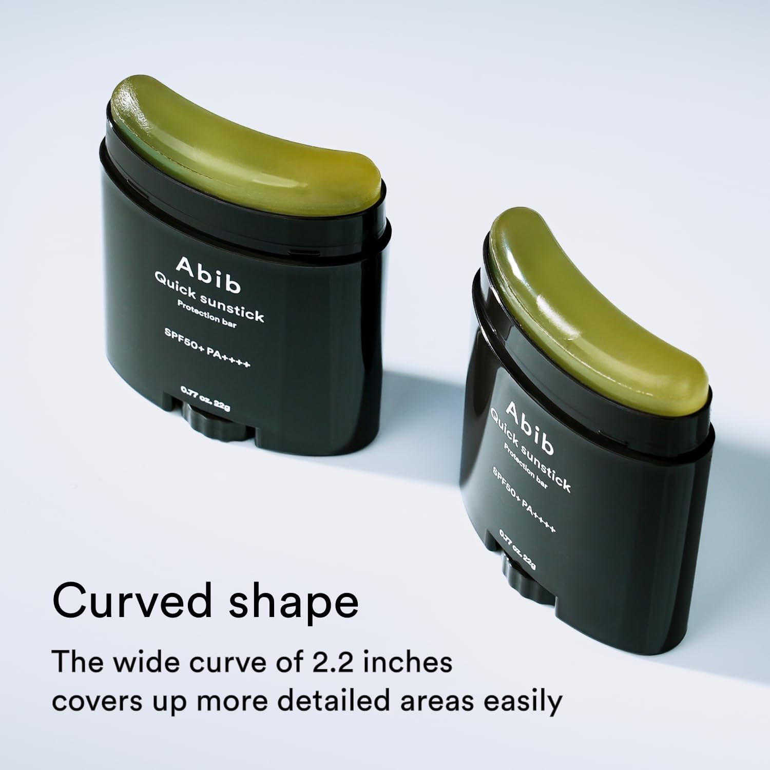 Two dark green Abib Quick Sunstick Protection Bars (22g) are displayed. They feature a wide, curved shape for detailed coverage and SPF50+ PA++++, enhancing skin barrier protection effortlessly with their 2.2-inch curve.