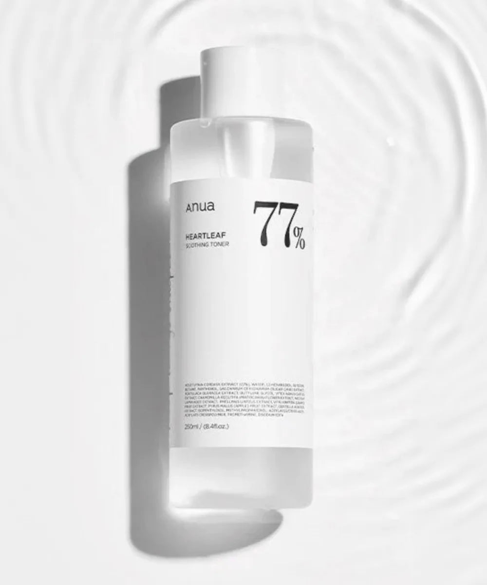 A clear 250ml bottle of ANUA Heartleaf 77% Soothing Toner rests on a rippled white surface, its minimalist label emphasizing the calming Houttuynia Cordata formula—perfect for refreshed, soothed skin. Brand: Anua.