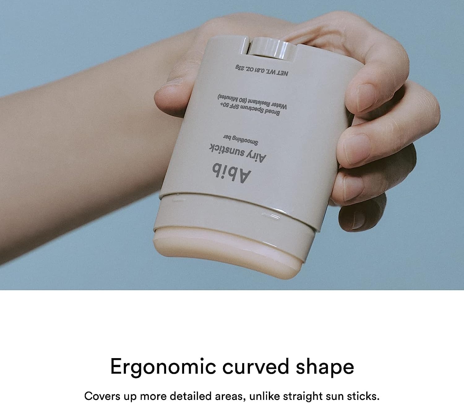 A hand holds the Abib Airy Sunstick Smoothing Bar with SPF50+ PA++++. Below, it says, Ergonomic curved shape for precise coverage, unlike straight sun sticks. The scene is set against a pale blue backdrop.