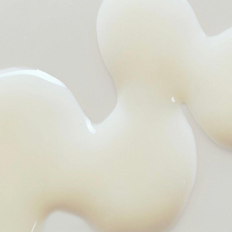 Close-up of ABIB Jericho Rose Bifida Serum spilled on a surface, showcasing its smooth, milky texture and lightweight, hydrating consistency.