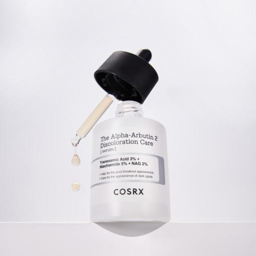 A COSRX The Alpha-Arbutin 2 Discoloration Care Serum 50ml bottle features Tranexamic Acid and Niacinamide, with a dropper for precision. The white bottle has a black cap and highlights its ingredients on a minimalistic label.