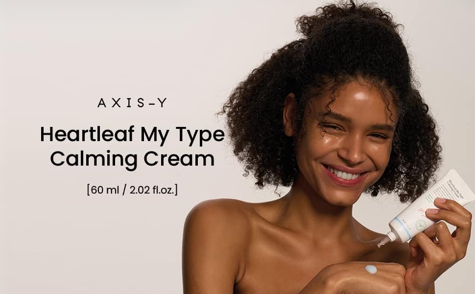 A person beams as they apply the AXIS-Y Heartleaf My Type Calming Cream, enriched with centella asiatica, to their shoulder. The plain backdrop displays the product name and size (60ml), highlighting its soothing properties.