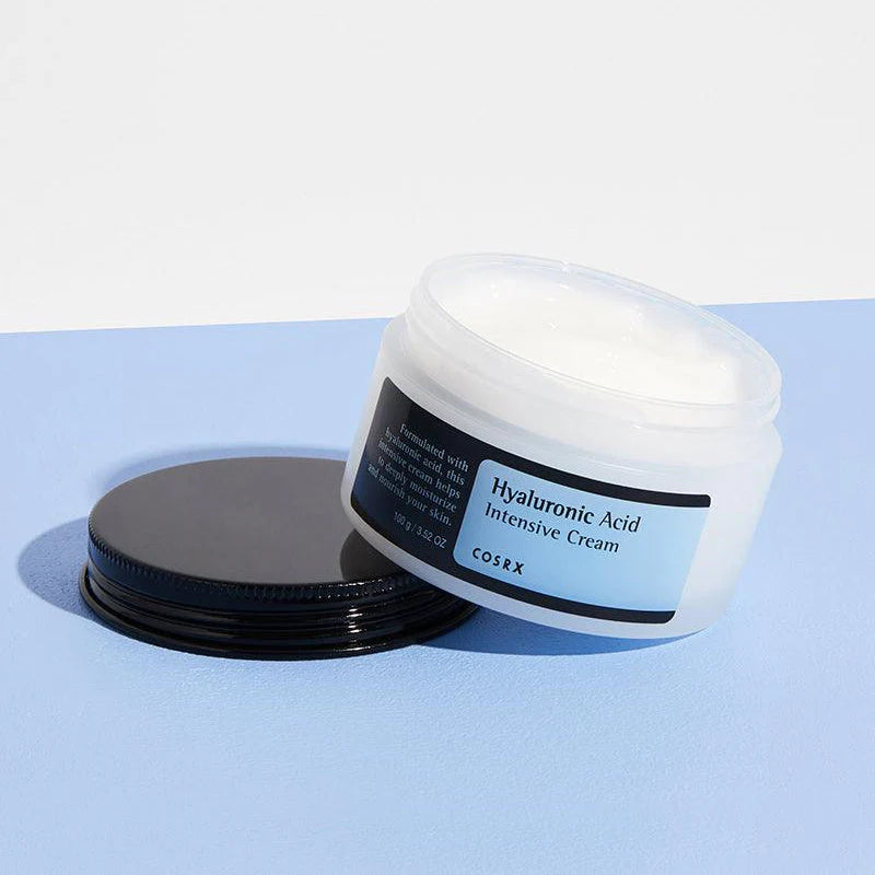 Open jar of COSRX Hyaluronic Acid Intensive Cream showing its rich, creamy texture. Designed for deep hydration, skin plumping, and moisture retention.