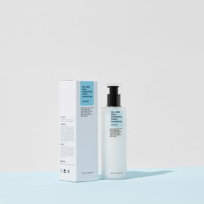 A bottle of COSRX Oil-Free Ultra Moisturizing Lotion (with Birch Sap), an ideal acne facial moisturizer, stands beside its box. The bottle has a black pump, and the predominantly white box features blue accents against a pale blue and white background, embodying clean beauty elegance.