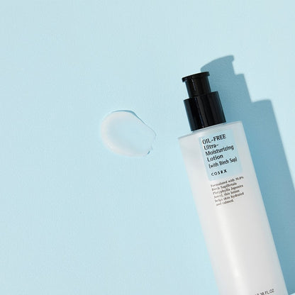 The COSRX Oil-Free Ultra Moisturizing Lotion (with Birch Sap), ideal as an acne facial moisturizer, is showcased against a light blue backdrop. A dollop of lotion lies next to the bottle, which has a sleek black pump.