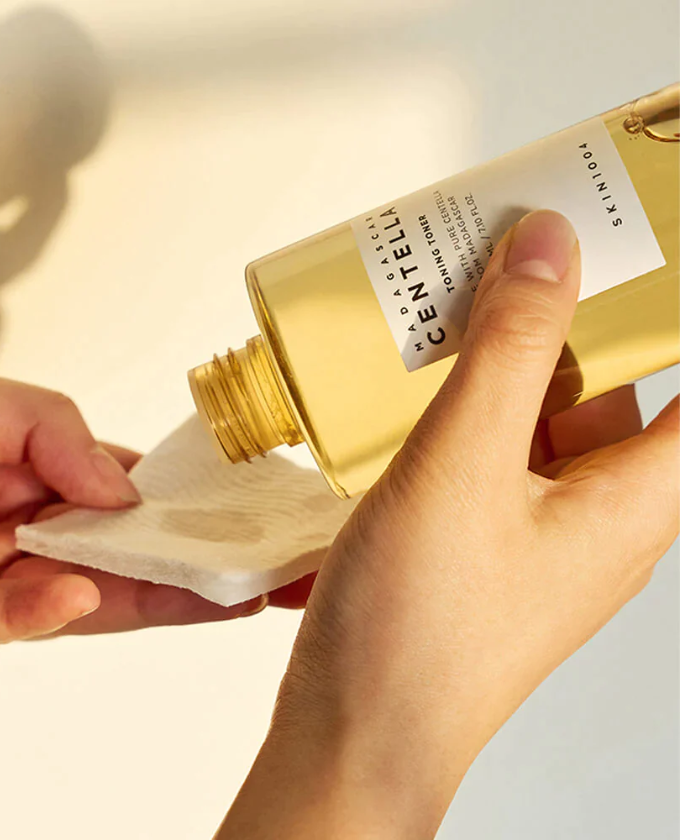 An image showing the toner being poured onto a cotton pad, illustrating its lightweight, watery consistency that absorbs quickly into the skin.