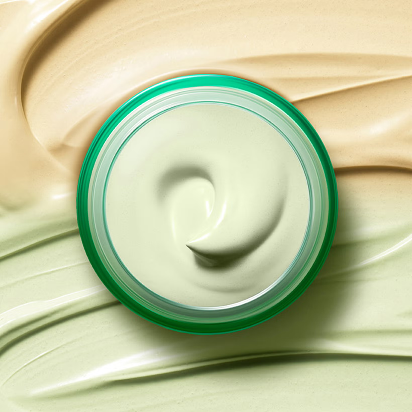 A glass jar of Dr.Jart+ Cicapair Tiger Grass Color Correcting Treatment 50ml is seen from above, surrounded by beige and green cream swirls, creating a soft, textured background—ideal for sensitive skin.
