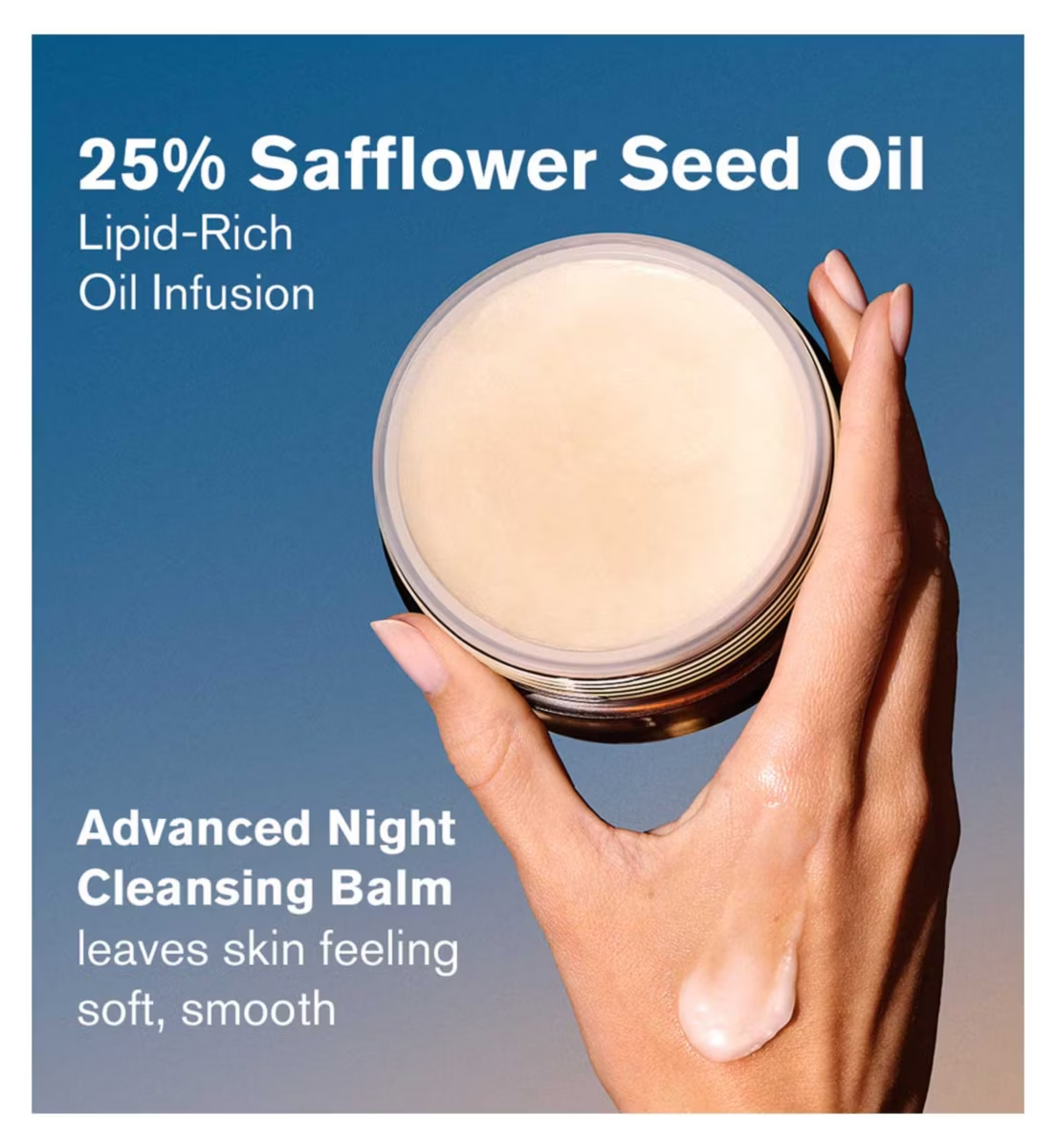 A hand holds an open jar of Estée Lauder Advanced Night Cleansing Balm with creamy texture, some applied on the back of the hand. Text: 25% Safflower Seed Oil. This balm leaves skin feeling soft and smooth. Brand: ESTEE LAUDER.
