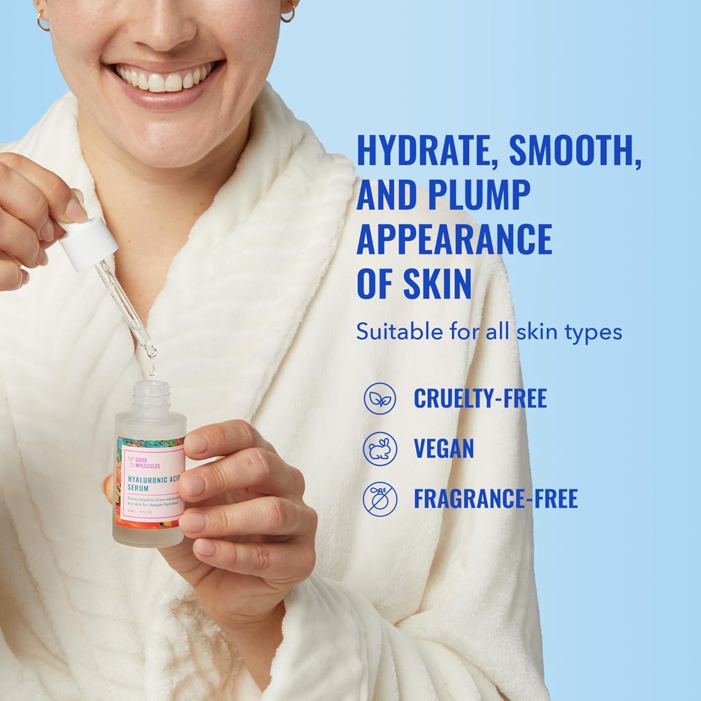A person in a white bathrobe smiles, holding a dropper of Good Molecules Hyaluronic Acid Serum over the bottle. Text on blue background says: Hydrate, smooth, and plump your skin for radiance. Suitable for all skin types. Cruelty-free, vegan, fragrance-free.
