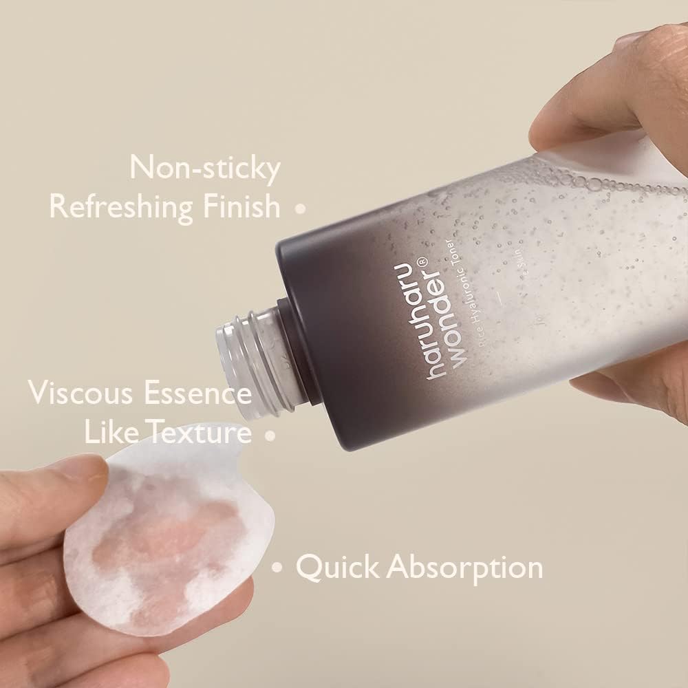 A hand pours Haruharu WONDER - Black Rice Hyaluronic Toner onto a cotton pad against a neutral beige background, showcasing its features: Non-sticky, Refreshing Finish, Black Rice & Hyaluronic Acid, and Quick Absorption.