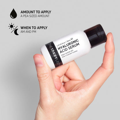 A hand holds a bottle of The INKEY List™ Hyaluronic Acid Serum - 30ml against a gray background, highlighting its moisture-binding power. Text advises using a pea-sized amount in AM and PM routines for effective fine line reduction.