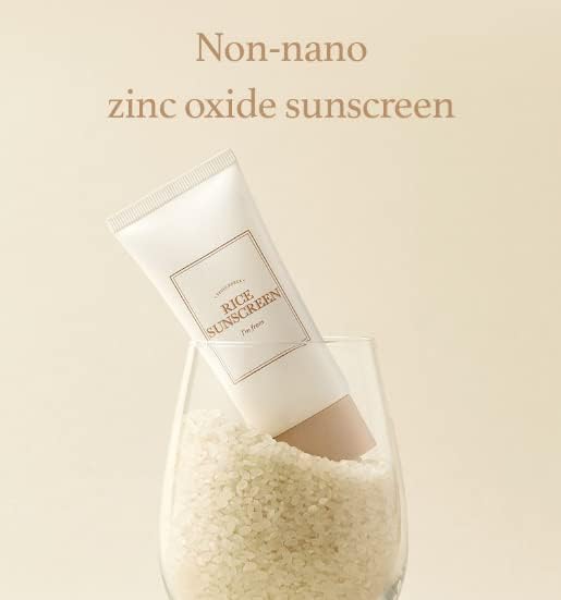 A tube of Im From Rice Sun Screen SPF50+ PA++++ by IM FROM rests in a rice-filled wine glass against a light beige backdrop, showcasing its superior protection.