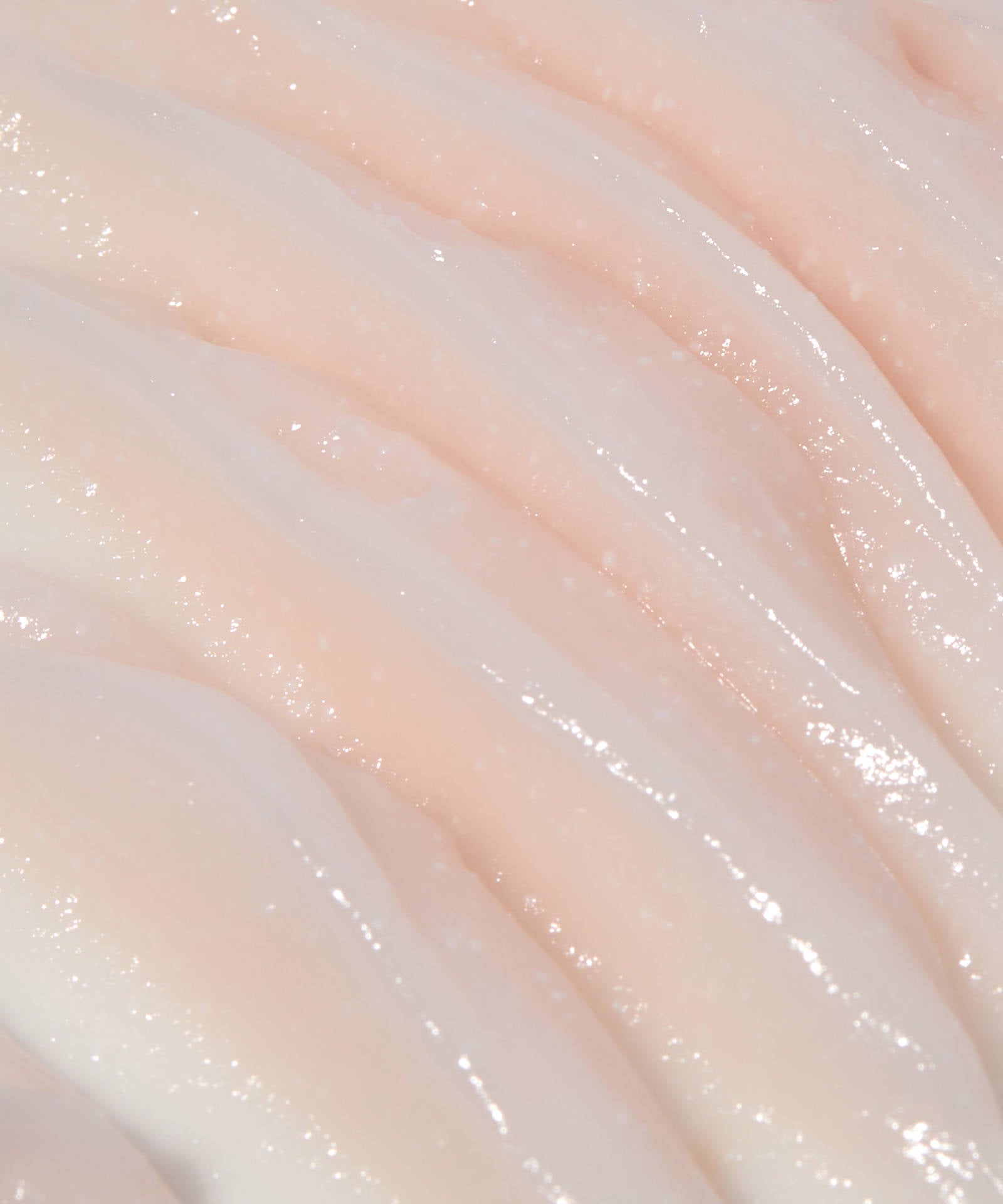 The Laneige Bouncy & Firm Sleeping Mask features a creamy, smooth surface with a light pink hue. Its wavy, glossy texture mirrors luxurious cream layers, reflecting light beautifully to enhance skin radiance and vitality.