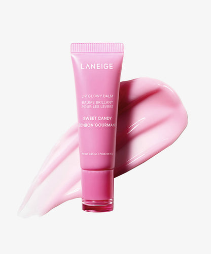 The Laneige Lip Glowy Balm - Sweet Candy 10g, enriched with shea and murumuru butters, rests on a glossy pink smear. Its white text displays the LANEIGE brand, ensuring a glass skin glow with each application.