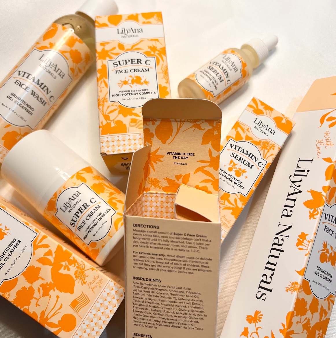 LilyAna Naturals skincare products with orange and beige packaging on a white background