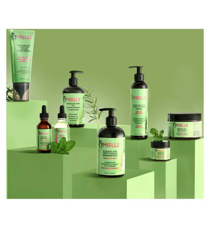 Mielle Organics hair care products on a green background