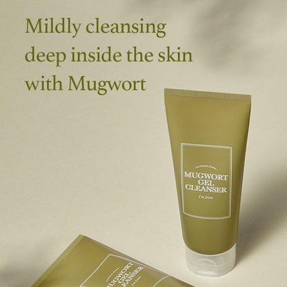 An olive green tube of Im From Mugwort Gel Cleanser 150ml by IM FROM sits on a light green surface. The text above reads, Mildly pore cleansing deep inside the skin with cold extraction of Mugwort. Shadows in the background add depth.