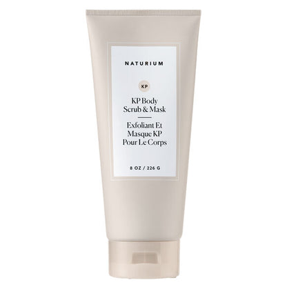 A beige tube of NATURIUM KP Scrub & Mask 226g stands upright, featuring minimalist English and French labels. This body exfoliator is designed for keratosis pilaris and showcases a chic, simple look.