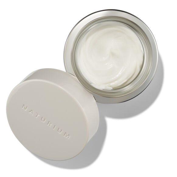 Open jar of cream with lid on a white background, featuring the brand 'Naturium'.