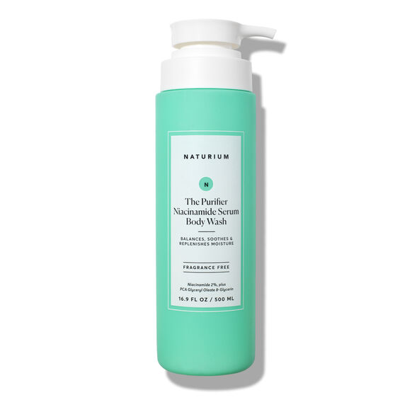 A green 500ml bottle of NATURIUM The Purifier Niacinamide Serum Body Wash with a white pump. This fragrance-free cleanser balances, soothes, and replenishes moisture for clarified skin.