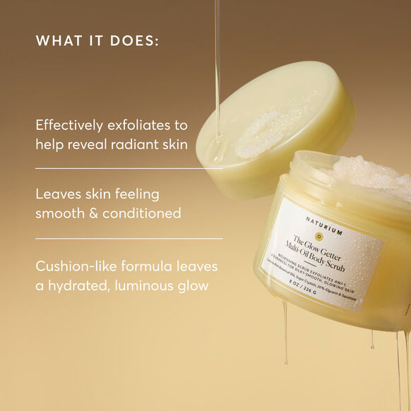 Naturium body scrub with open jar and exfoliating glove on a beige background