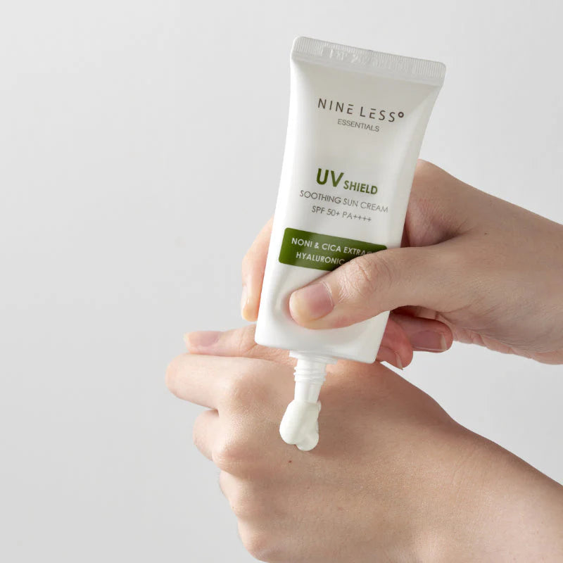 Hand holding a tube of Nine Less UV Shield Soothing Sun Cream with a small amount on the tip.