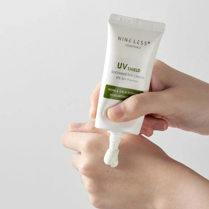 Hand holding a tube of Nine Less UV Shield Soothing Sun Cream with a small amount on the tip.