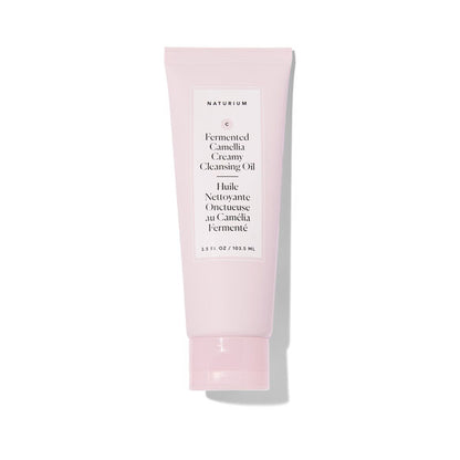 A light pink squeeze tube of Naturium Fermented Camellia Creamy Cleansing Oil on a white background with a soft shadow.