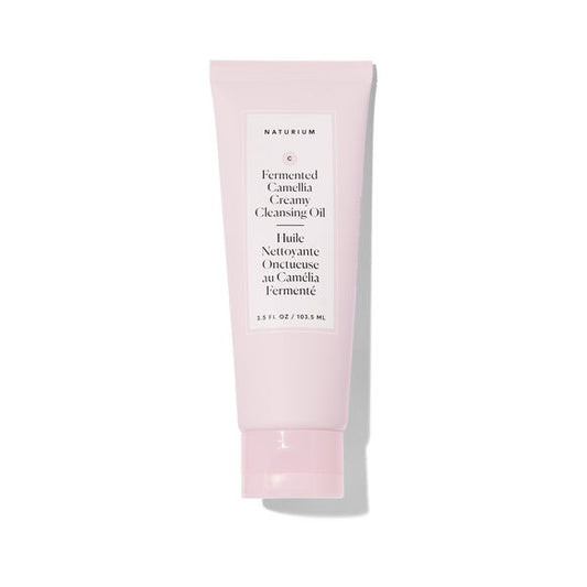 A light pink squeeze tube of Naturium Fermented Camellia Creamy Cleansing Oil on a white background with a soft shadow.