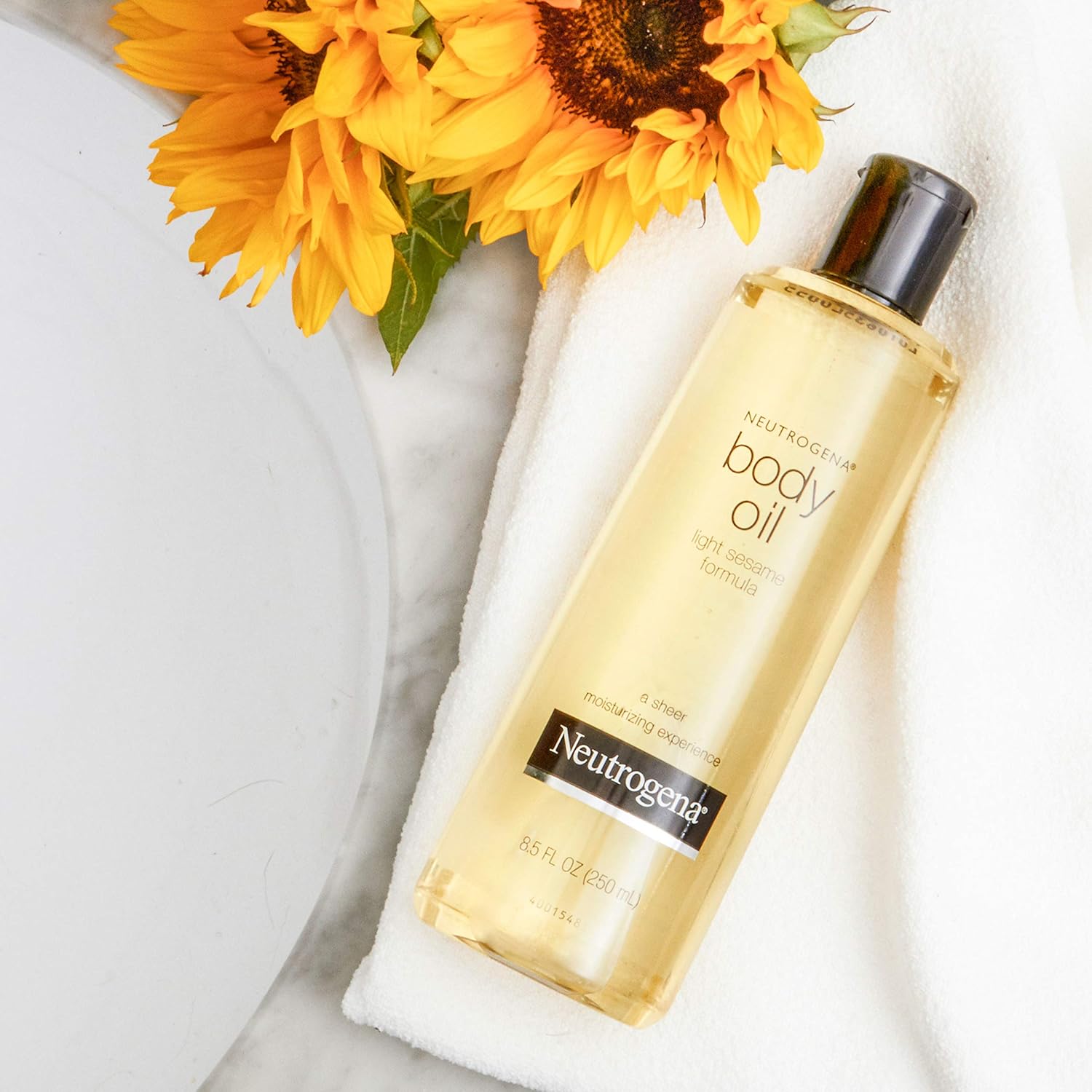 Neutrogena body oil bottle with sunflowers on a white background