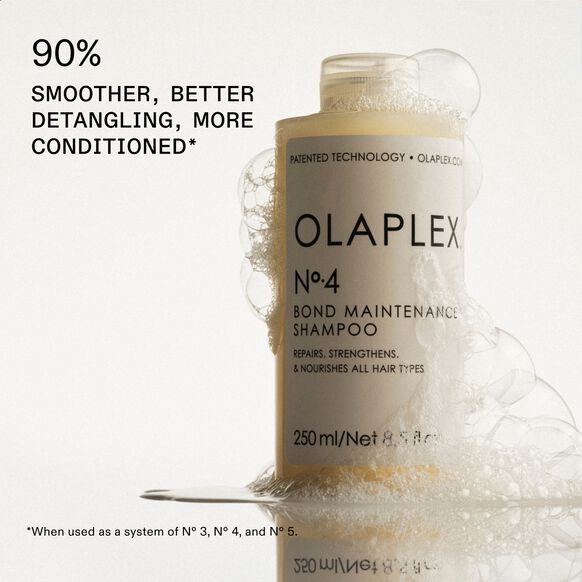 A 100ml bottle of OLAPLEX No.4 Bond Maintenance Shampoo covered in suds, with text: 90% smoother, better detangling, more conditioned.* *Results from using the 3-4-5 Bond Maintenance System (No.3, No.4 & No.5) to repair broken bonds.