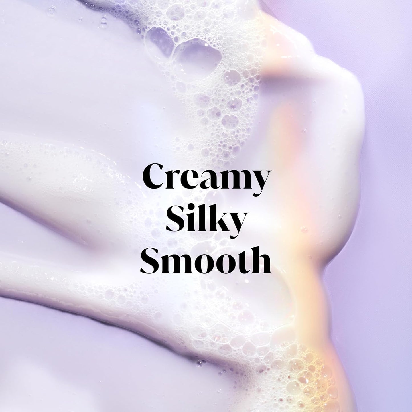 Close-up of a person's shoulder with soap suds and text 'Creamy Silky Smooth' on a light purple background.