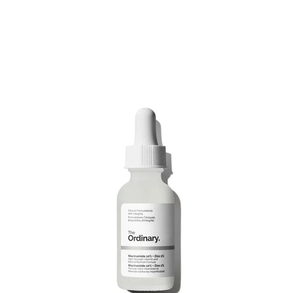 A translucent dropper bottle of The Ordinary Niacinamide 10% + Zinc 1% 30ml serum sits on a white background. Ideal for blemish-prone skin, it features a white label with black text and a sleek white dropper cap.