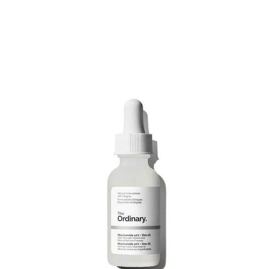 A translucent dropper bottle of The Ordinary Niacinamide 10% + Zinc 1% 30ml serum sits on a white background. Ideal for blemish-prone skin, it features a white label with black text and a sleek white dropper cap.