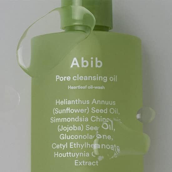 A green bottle of Abib Pore Cleansing Oil Heartleaf Oil-Wash 200ml shines with water droplets. This cleanser, by Abib, deeply cleans pores with ingredients like Sunflower Seed Oil, Jojoba Seed Oil, and Houttuynia Cordata Extract.