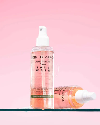 Two bottles of 'Acne Control Glow' face wash by Zaro on a pink background