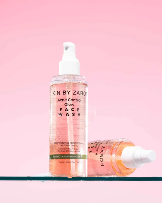 Two bottles of 'Acne Control Glow' face wash by Zaro on a pink background